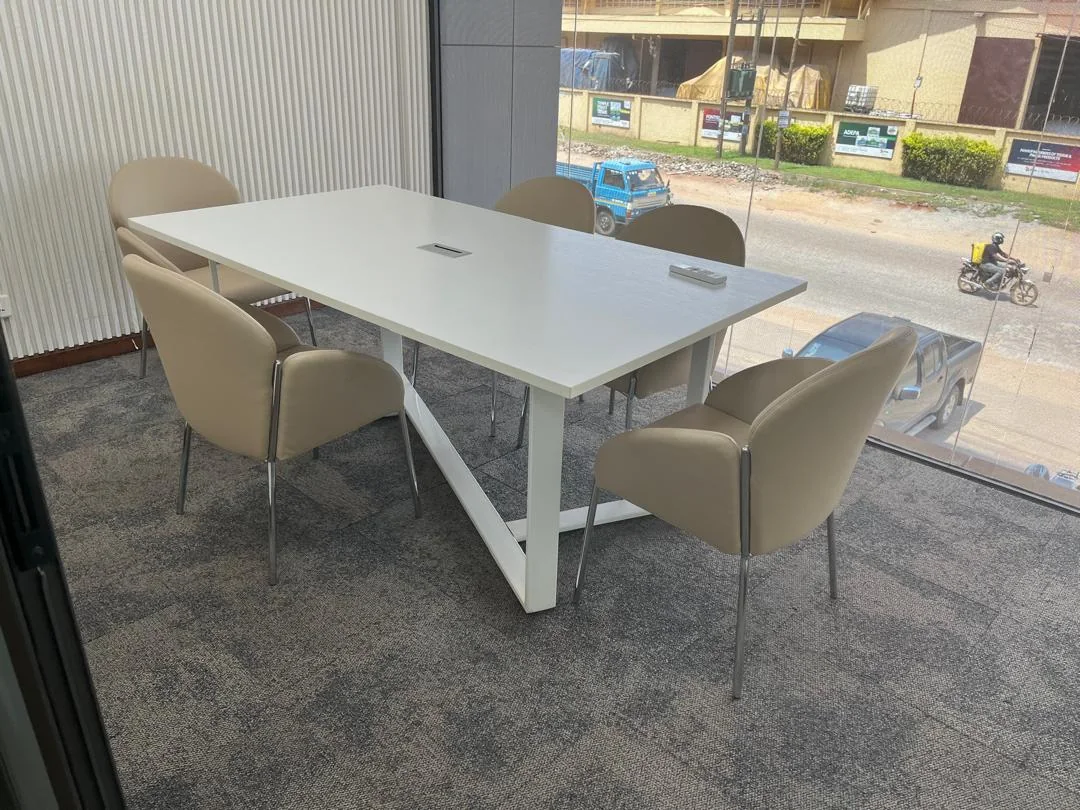 Meeting room with a bespoke white conference table and taupe chairs